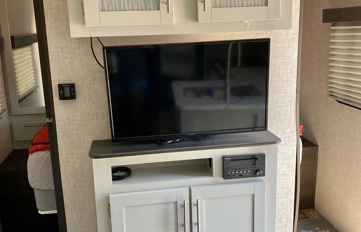 TV with DVD player, and radio. Games for the family in the lower cabinet, with DVDs in the top cabinet.