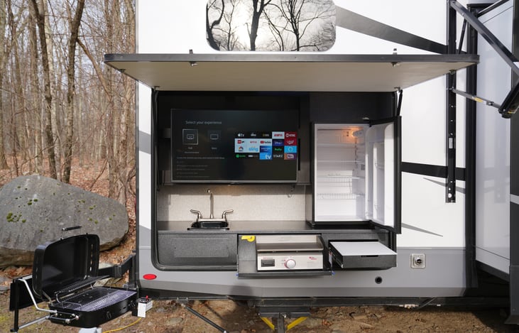 Outdoor entertainment area includes 43' smart TV, large fridge, sink, swing out gas grill, and slide out griddle.