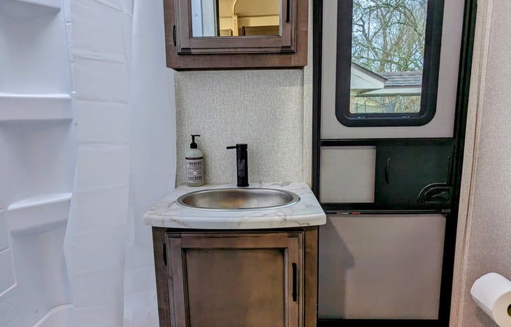 Bathroom with shower, under-sink storage space and medicine cabinet with additional storage
