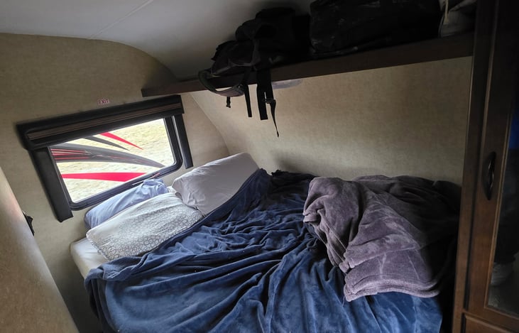 Private Bedroom with full size mattress, overhead storage and a closet with a mirror