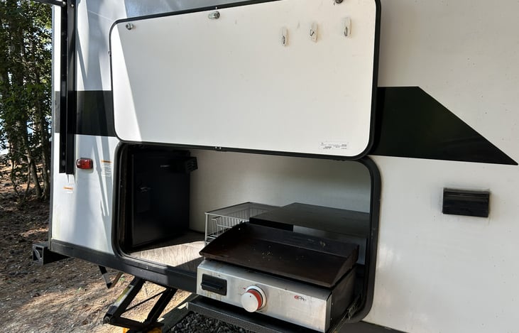 Outdoor kitchen with griddle and small fridge