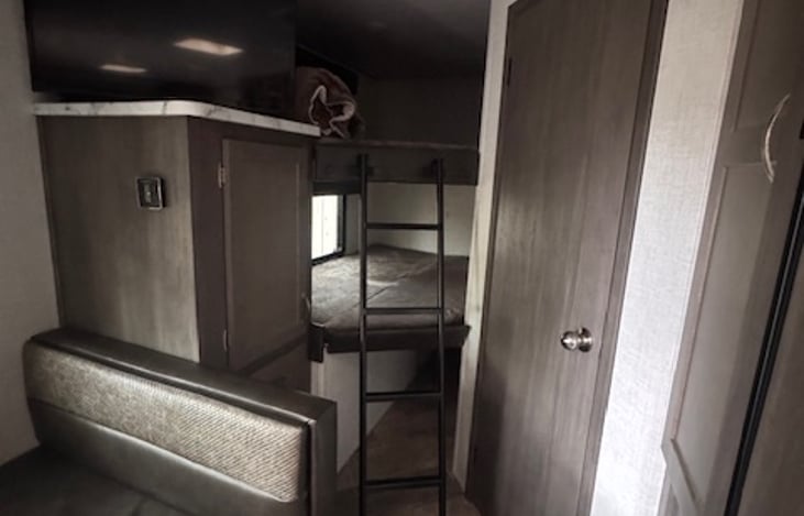 Cozy double bunk with swivel tv and storage cabinet.