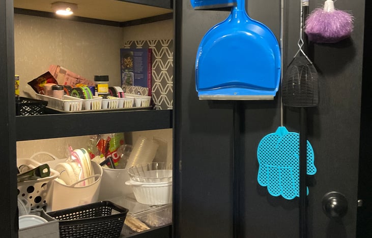 Pantry has lots of storage. These are the two middle shelves with paper products, spices, cookbook.

Cleaning tools hang conveniently from the inside door.