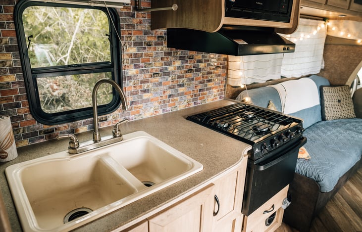 Kitchen includes a gas range oven as well as a microwave.