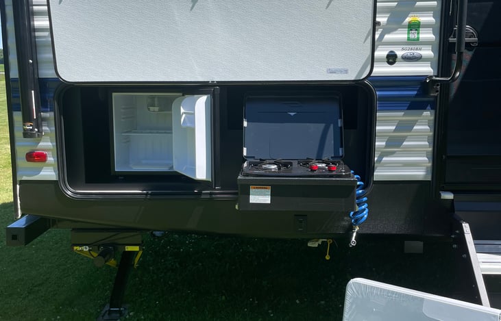 Outdoor kitchen, stovetop, fridge, 4’ folding table & spray nozzle.