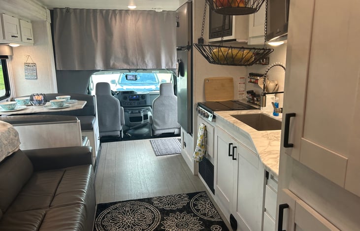 Looking from the bedroom, the kitchen is on the right and couch and dinette are on the left. The curtain is closed on the overcab.