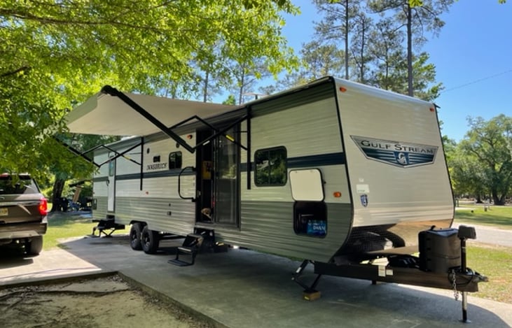 Passenger side with the super-size power awning fully extended. Two entries with front exterior storage.