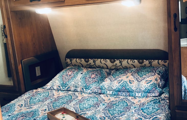 Queen bed with memory foam mattress, storage closets on both sides of bed with overhead lighting, and more storage up top...TV swivels for bedtime viewing...