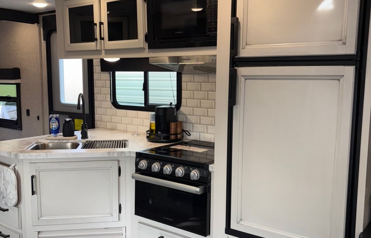 Open concept kitchen. Double basin sink, Oven, Microwave, Stove, and Fridge. In the cabinets you will find all of the essentials and more! Although due to space there are limited spices.