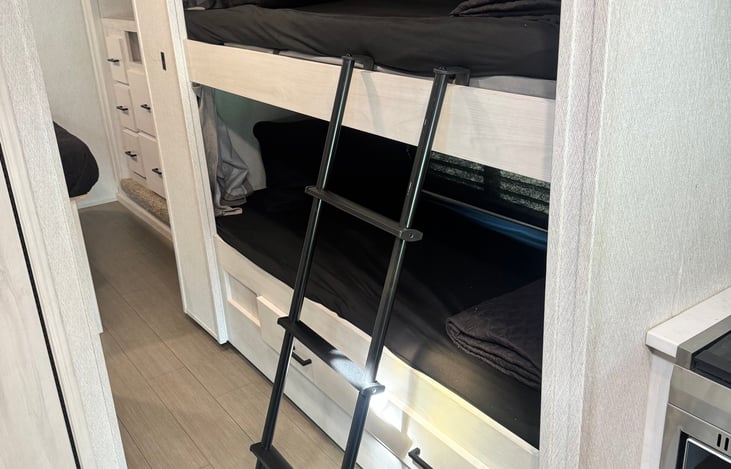 Two bunk beds with a child safety upper rail that can be easily used or tucked away. Drawers for extra storage underneath the bunk beds. Each bunk has outlets and a window.