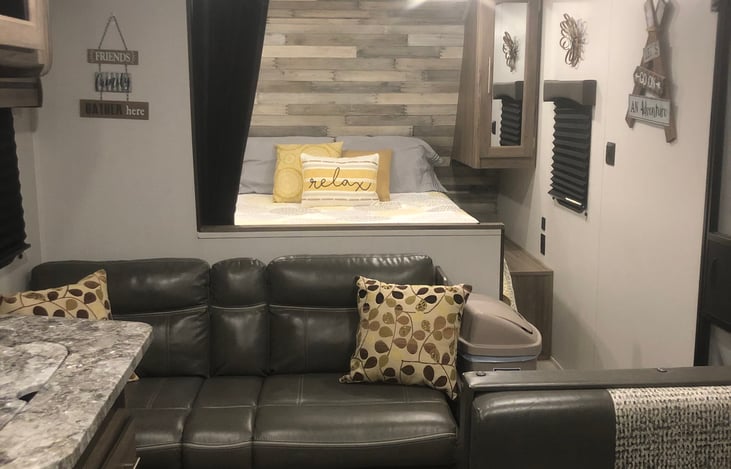 View from kitchen looking onto the couch and into the master queen size walk around bed.  Privacy curtain separates bedroom from the living quarters