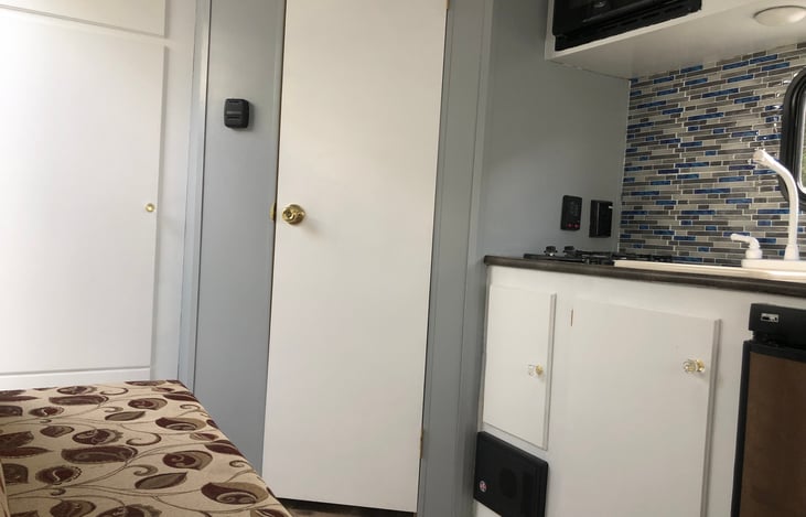 2 burner stove next to kitchen sink, microwave ovn above