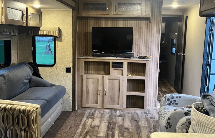 Tv with DVD player, radio and storage. Storage above couch and recliners. Recliners can be moved out from wall and can lay out for extra sleeping.