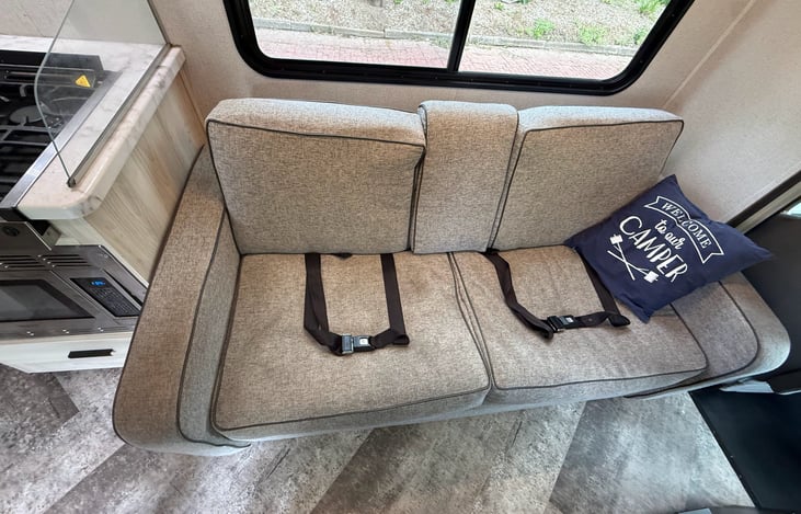 Our couch that can fold down into a small bed. Two of six seatbelts here. Middle of the couch folds down for cup holders.