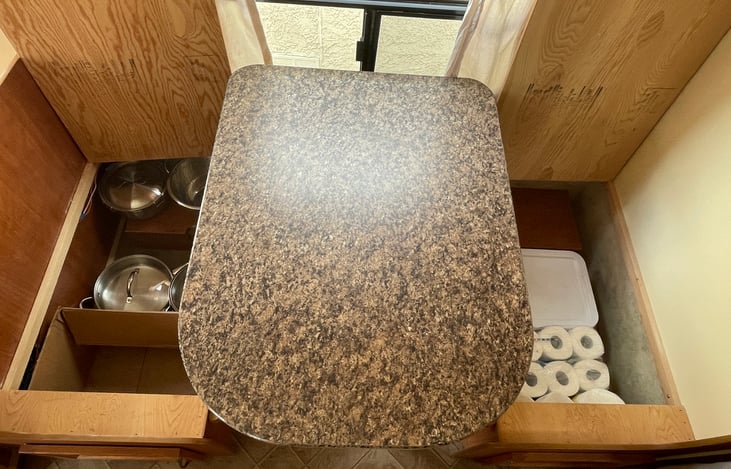 Dinette storage right side:
- 2x stainless steel pots
- 2x stainless steel pans
- 1x strainer (stainless steel)
- bowls set of three w. lids (stainless steel)
Left side: toilet paper & paper towels