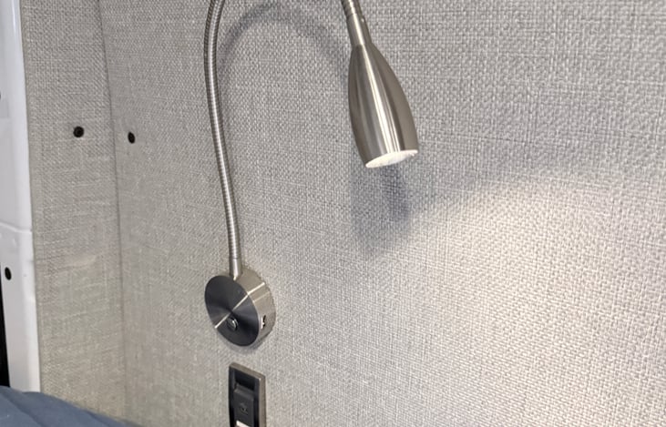 Lighting next to main bed with charging ports.