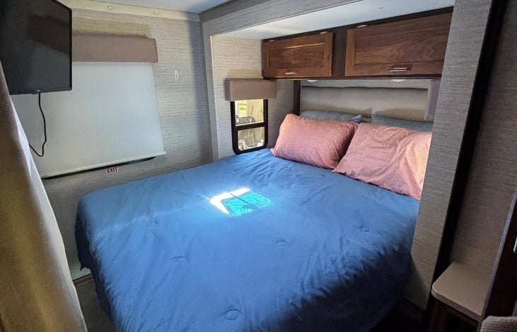 Bedroom with slide out, queen bed and TV.