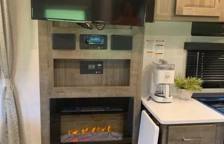 Featured as well is a built-in electric fireplace and a 12V Smart Entertainment TV linked to an omnidirectional Winegard Air 360+ system pre-routed for Wi-Fi extensions.
