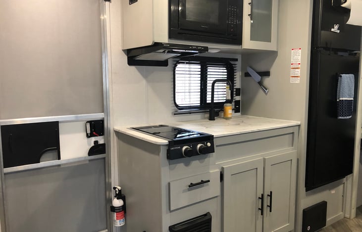 Large counter, 2 burner cooktop, dishes and cookware provided, large fridge