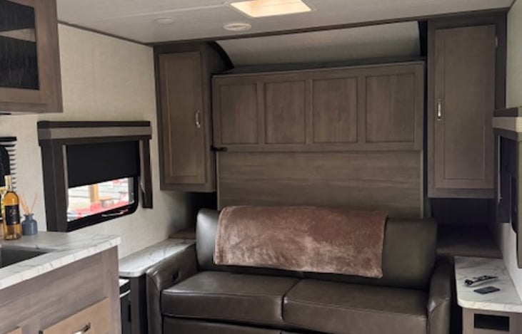 Fold down Queen size bed, with blankets, sheets, and pillows