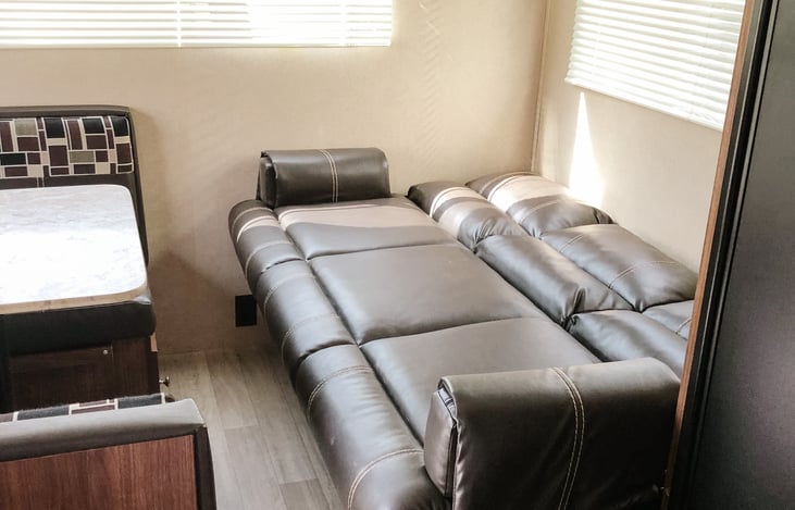 Jack knife sofa bed with underneath storage that has extra bedding and sleeping bags.