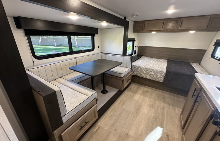 Interior overview showing dinette, kitchen walkway, and main bed area.