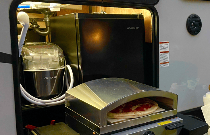 Outdoor bbq area, with pizza oven attachment,mini fridge, ice maker and shower.