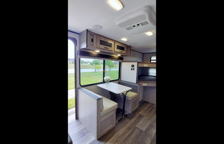 AC/Heat controls at ceiling, LG operable window w/ screen, storage above & below 1 bench seat, kitchen table folds to small child bed, 2 LG bunks (200lb capacity ea) w storage niche, 1 outlet