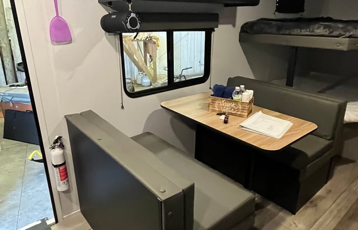 Dining table converts to short double bed. Also features storage cabinet overhead, and 2 additional storage compartments below the seats. Note: BT speaker to for your listening enjoyment!