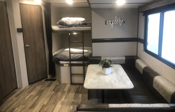 Horseshoe dinette, double sized bunk beds, bathroom door to the left of bunk beds