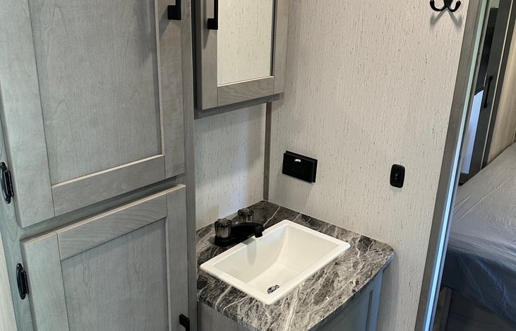 bathroom sink area with storage and medicine cabinet.