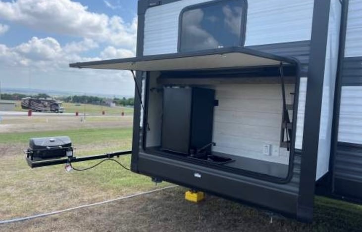 Outdoor mini fridge, sink and gas grill.