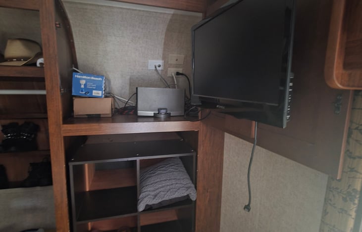 Master bedroom entertainment center with TV and shelving for extra storage