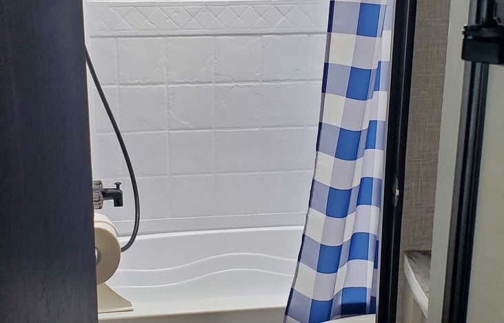 tub shower, toilet, sink outside of restroom