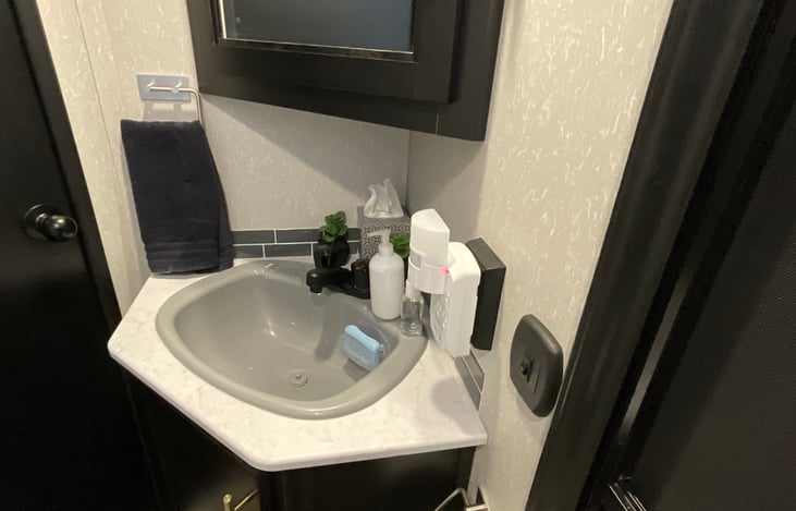 Bathroom includes corner vanity with mirror and sink, bathtub/shower, foot flush toilet. We added extra electrical and USB plugs, hand towel bar, toilet paper dispenser.