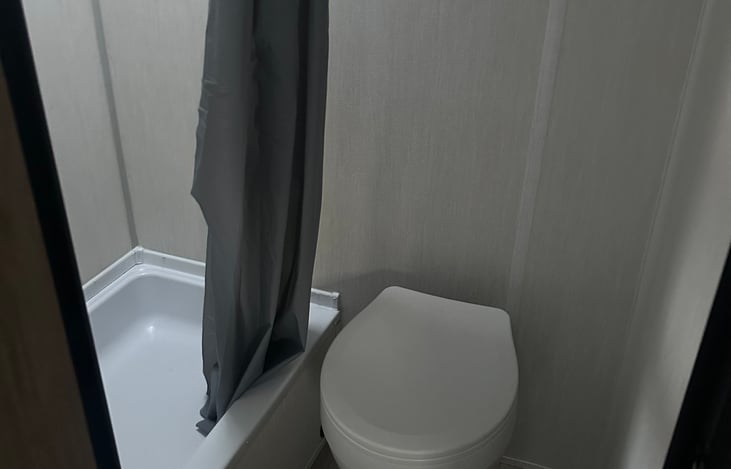The bathroom includes a standing shower and toilet.