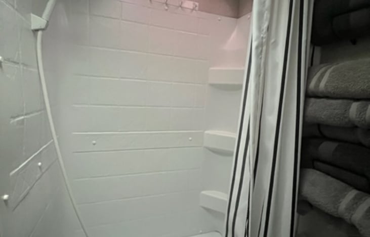 Full shower with shelves and a tub for small kids. There are covers that allow for the the tub to hold water.