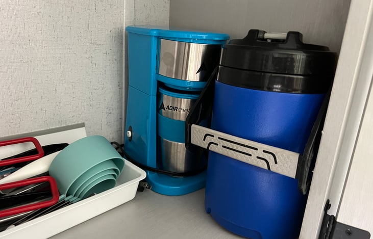 Single cup coffee maker, kitchen utensils and a 64 oz water jug are included.