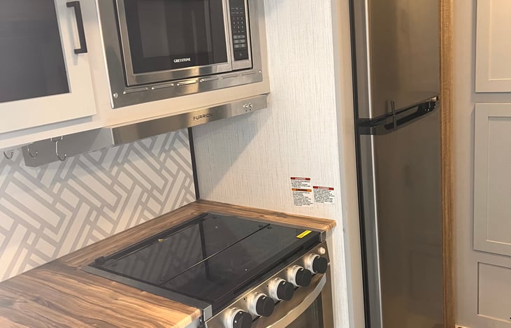 Kitchen area. Gas stove top and oven, microwave, refrigerator.