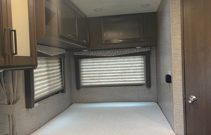Plenty of cabinet space above the bed with linen and a set of towels