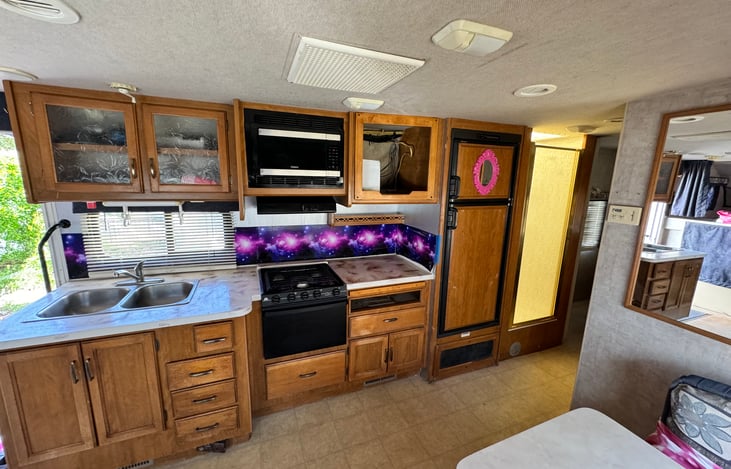 Full kitchen with stove, microware, sinks, fridge.