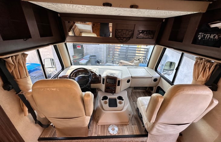 Passenger seat has fold out laptop table. Additional circle table provided to set up in between seats. Seats rotate 360 to face the RV living space when not driving.