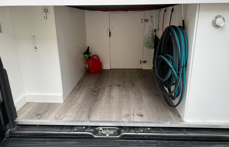 Garage under the bed with a lot of room for bikes and if you open the door you can probably fit skiis or a sur**oard. The garage has all of the necessities including a USB and outlet panel on the left