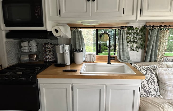 Functional kitchen with everything needed including a coffee maker, microwave, waffle maker, extra single burner electric burner, quesadilla maker, etc.