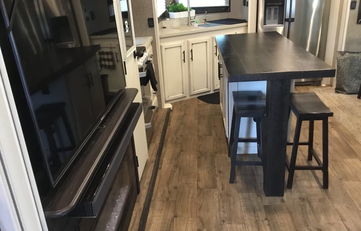 Kitchen area, island, tv, and fireplace