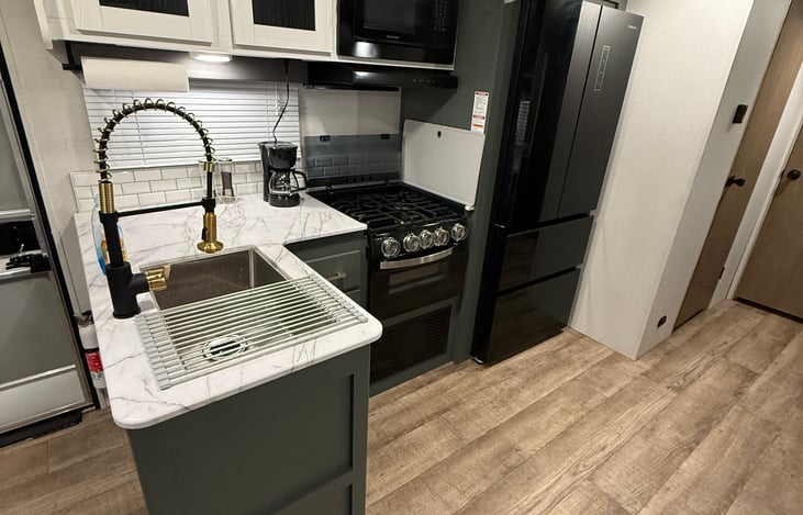 A full kitchen with full size fridge, sink, 3 burner stove, oven and microwave! Cooking and eating essentials provided! Coffee maker and filters provided, but you’ll need to bring your own grounds!