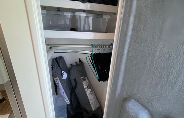closet with 2 chairs and storage bins
