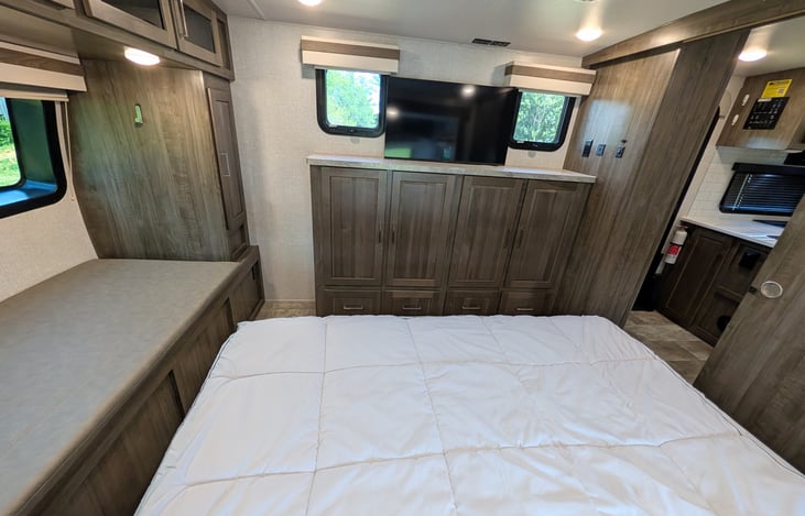 Private front bedroom features a walk-around Queen bed, TV, ample wardrobe storage, and a cozy built-in window seat nook—perfect for relaxing with a book! Full of natural light from 6 windows.