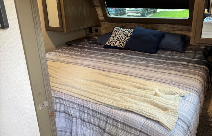 King size bed at the front of the camper that has a door for extra privacy as well as 3 window and a skylight for lots of natural light.