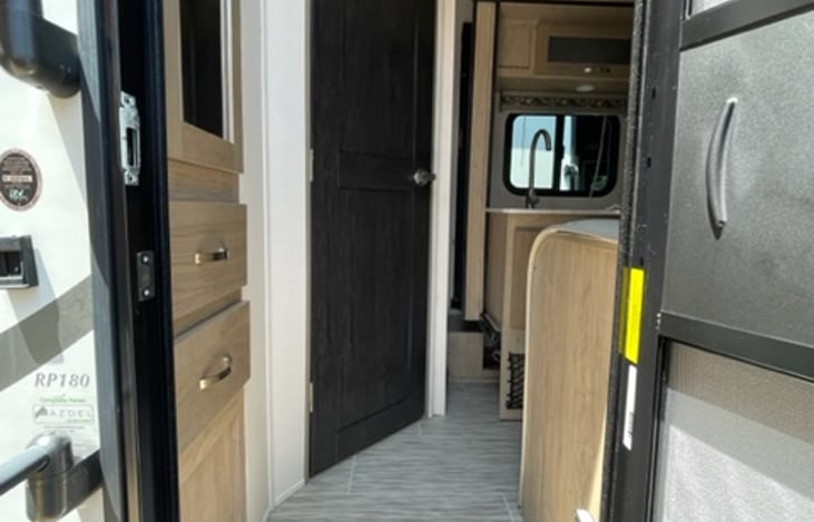 The travel trailer's interior entrance welcomes you with its stylish and functional design.